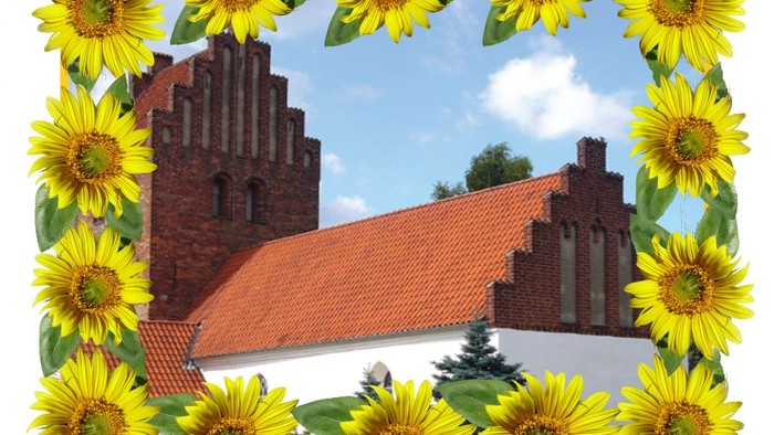 Et historisk murstensbygning indrammet af livlige gule solsikker mod en klar himmel.