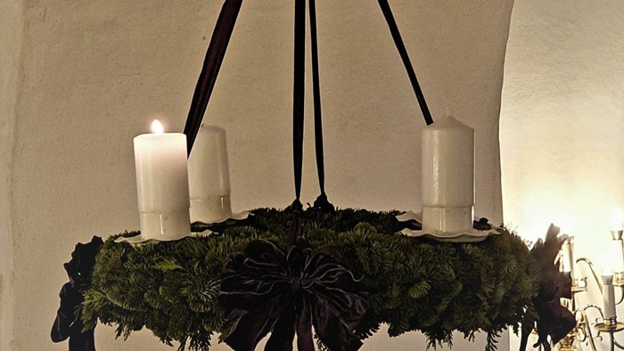 En kranse med lys og blomster hænger fra takken