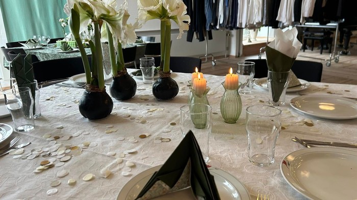 Bord dækket til spisning med blomster, stearinlys og servietter