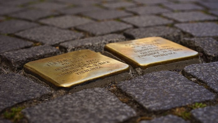 Zwei goldene Gedenkplatten auf Kopfsteinpflaster