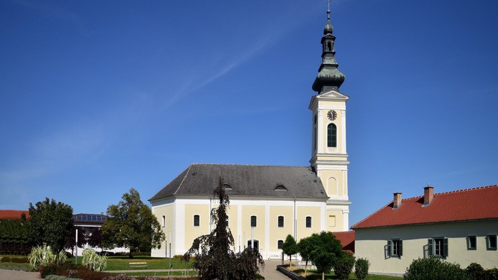 Weiße Kirche mit hohem Turm und blauen Himmel