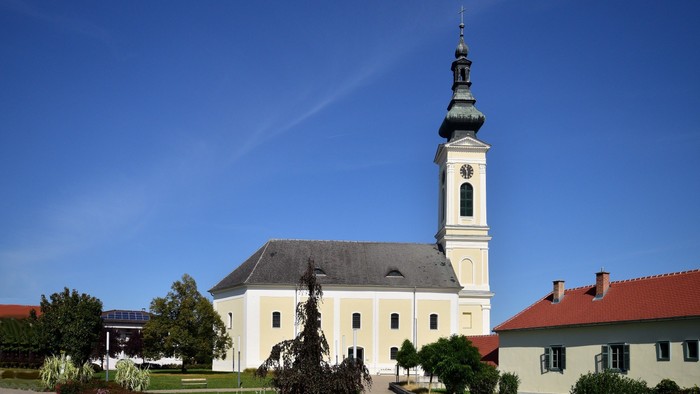 Weiße Kirche mit hohem Turm und blauen Himmel