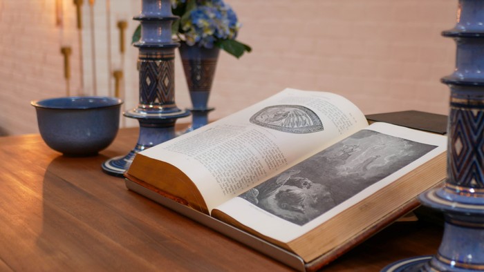 Åben bog på bord med dekorative genstande