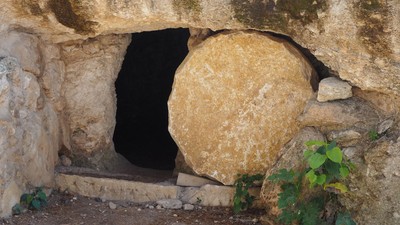 Ein großer Stein versperrt den Eingang zu einer Höhle in einer Felswand