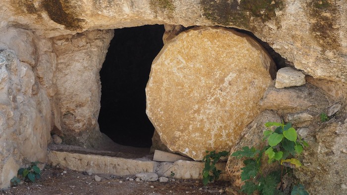Ein großer Stein versperrt den Eingang zu einer Höhle in einer Felswand