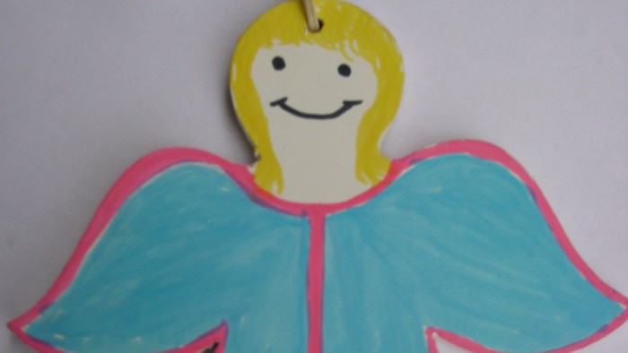 Ein bemaltes Holzengel-Weihnachtsschmuckstück mit blonden Haaren und blauen Flügeln