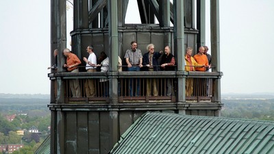 Einige Personen stehen auf einer Aussichtsplattform eines Turms.