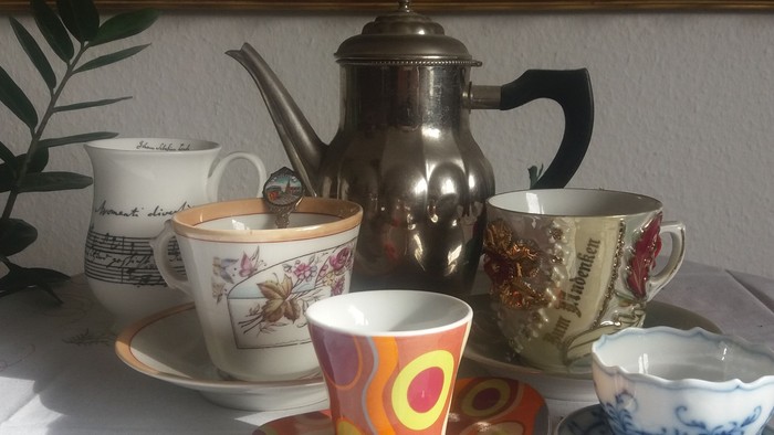 Vier Tassen und eine Kanne auf einem Tisch