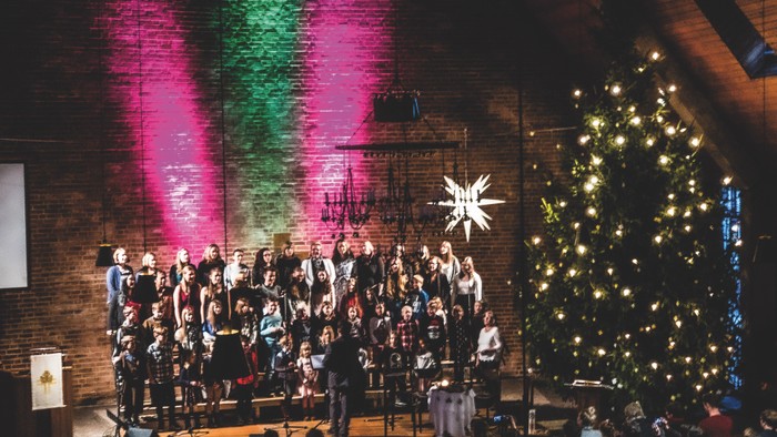 Kirchenchor tritt vor einem Weihnachtsbaum auf