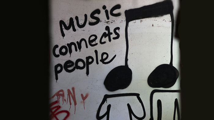 Graffiti: Music connects people, Doppelachtelnote, die gleichzeitig die Köpfen von 2 Figuren sind