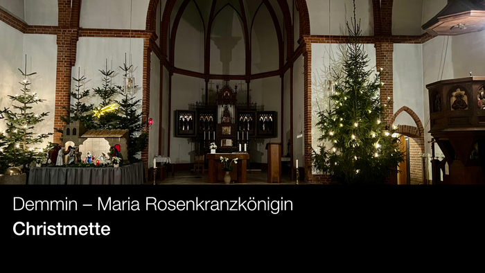 Innenraum der Kirche mit Weihnachtsbäumen und Altar, beschriftet mit