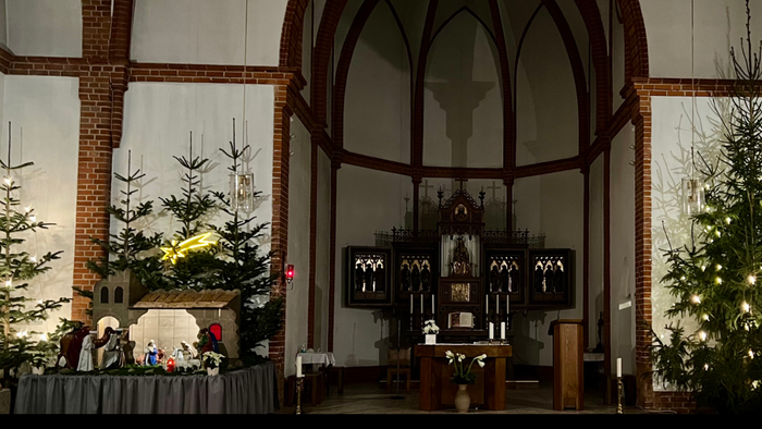 Innenraum der Maria Rosenkranzkönigin Kirche mit Weihnachtsbäumen und Altar