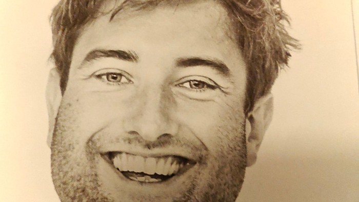 Mand med skæg smiler.