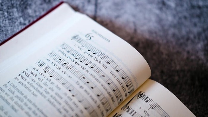 Offenes Buch mit Notenblättern auf einer grauen Oberfläche