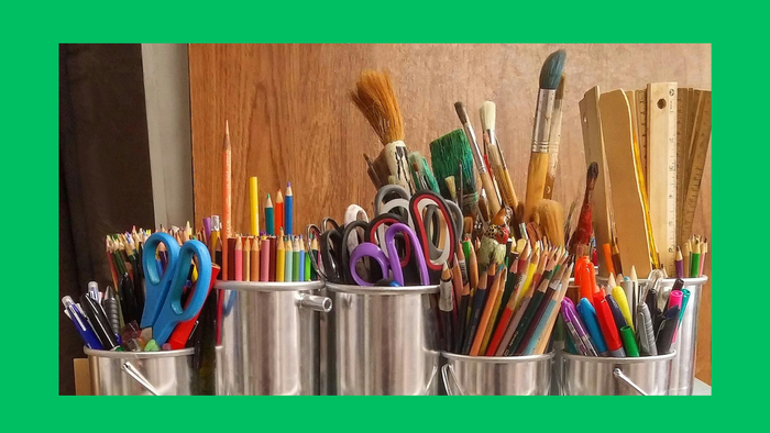 Viele Kunstmaterialien in Metallbehältern auf einem Regal