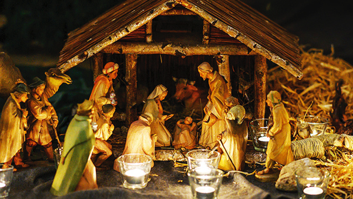 Eine detaillierte Weihnachtskrippe mit Figuren und Kerzen.