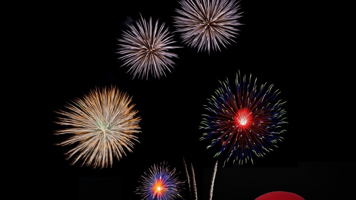 Bunte Laternen und Feuerwerk am dunklen Himmel