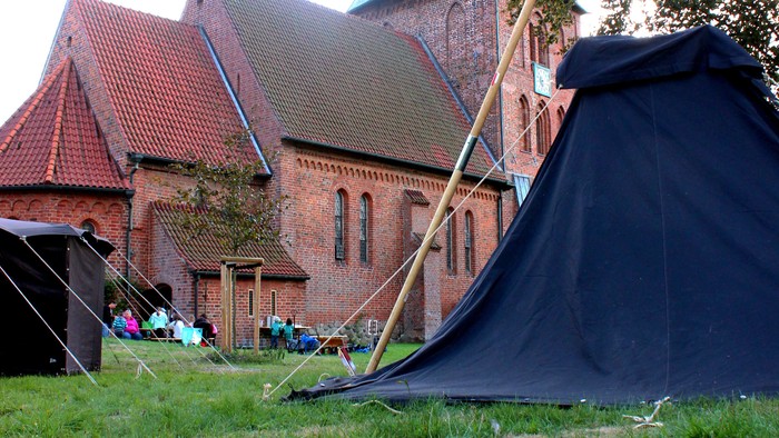 Zelt auf dem Rasen vor einem Backsteingebäude