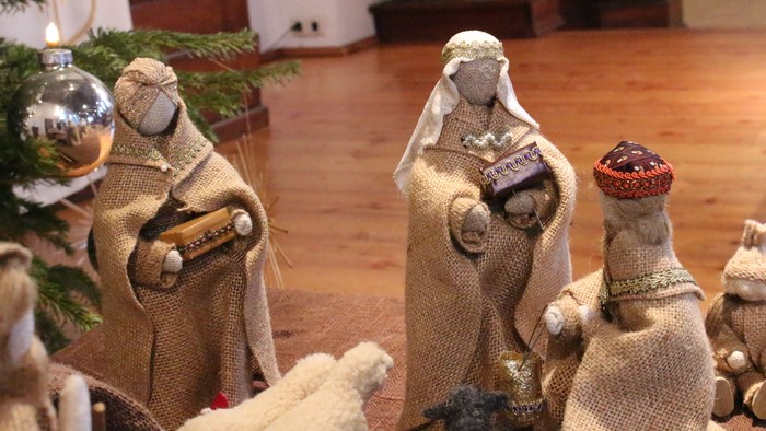 Eine Krippe mit Strohfiguren, Weihnachtsbaum und Kugeln