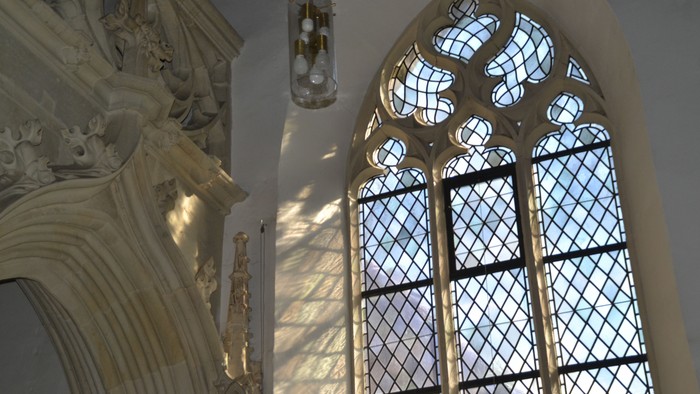 Ein Kirchenfenster mit Buntglas und verzierten Steinmetzarbeiten