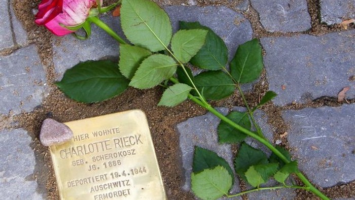 Eine Rose liegt auf einem Gedenkstein für Charlotte Rieck.