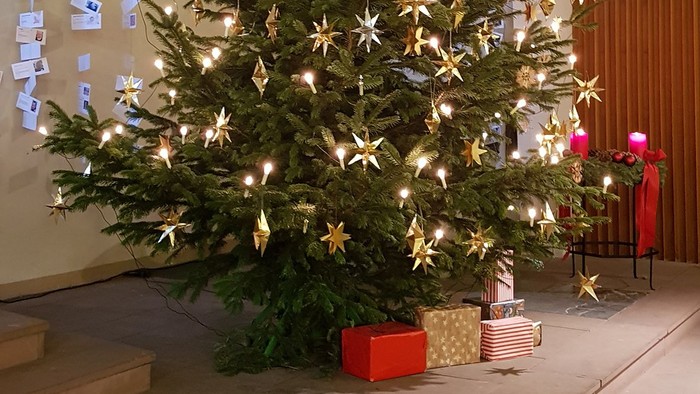 Ein geschmückter Weihnachtsbaum mit Lichtern und Sternen in einem Raum