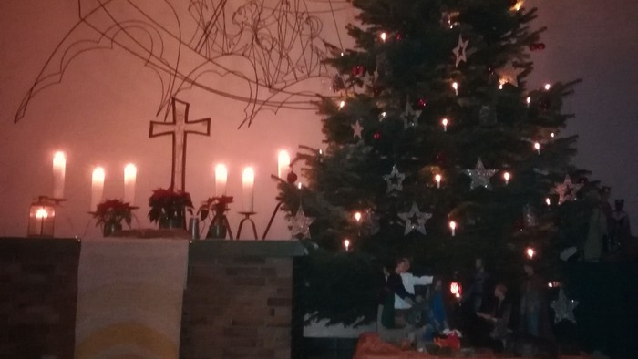 Weihnachtsbaum mit Kerzen und Krippe in Kirche