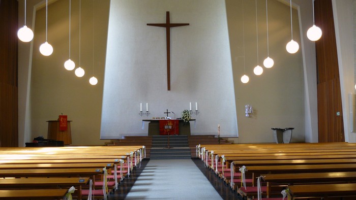 Leere Kirche mit Holzbänken und Kreuz