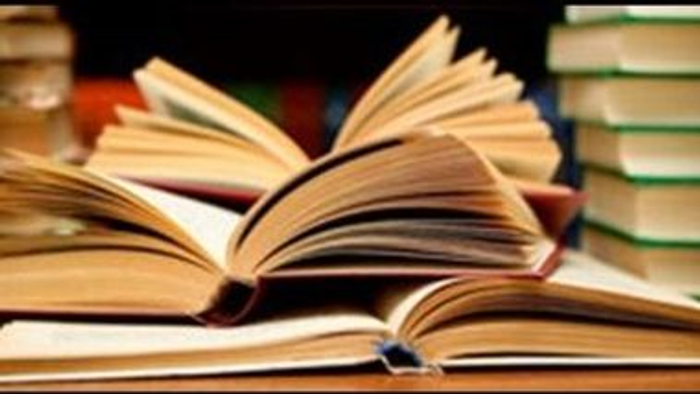 En samling åbne og lukkede bøger på en bord.