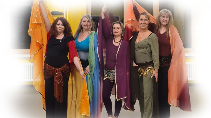 Ein Gruppenfoto von sechs Frauen in farbenfrohen Gewändern