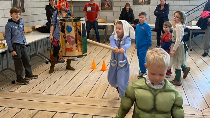 Børn, der leger i et rummeligt rum, mens voksne observerer.