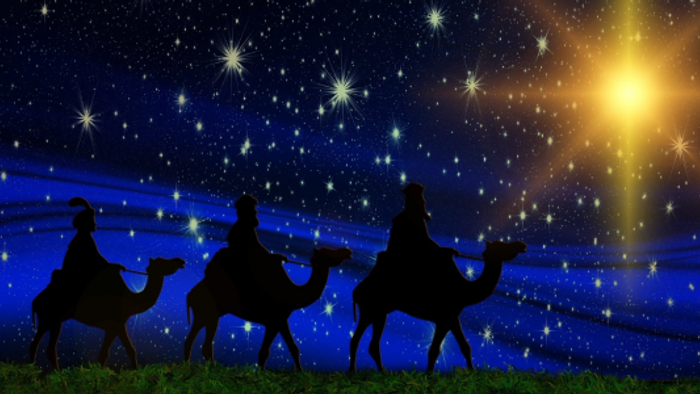 Tre kameler og deres ridere på en stjernet natt