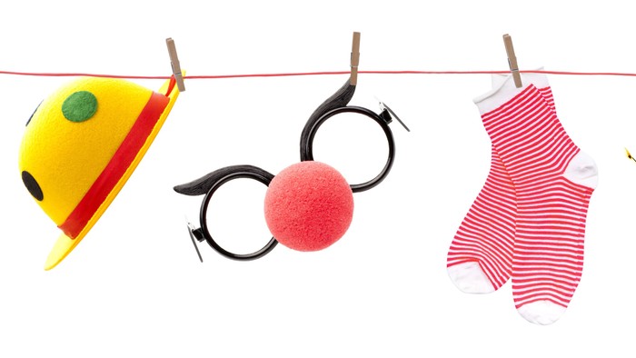 Billedet viser en kile med forskellige børnespiller og legetøj hængende på en klædeklippe.