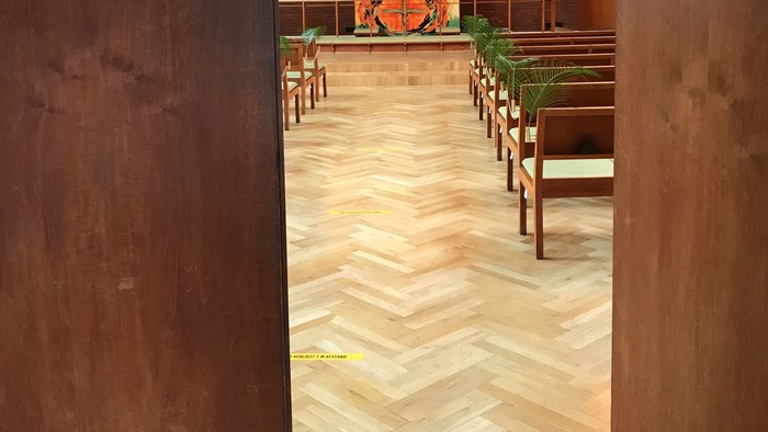 Indgang til kirke med alter og bænke.