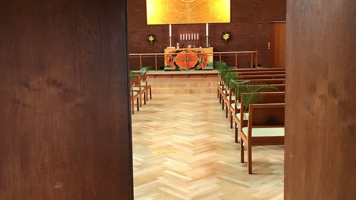 Indgang til kirke med alter og bænke.