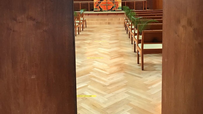 Indgang til kirke med alter og bænke.