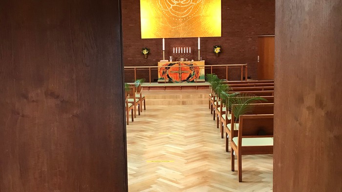 Indgang til kirke med alter og bænke.