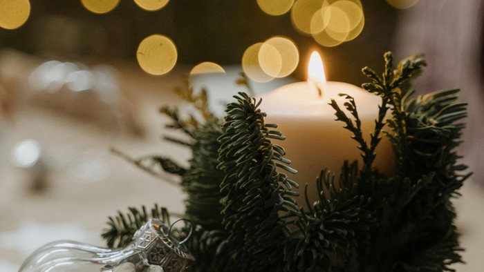 Weihnachtliche Tischdekoration mit Kerze und Tannenzweigen