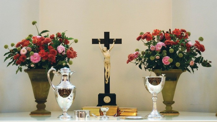 Altaret er dekket med blomsterarrangementer og religiøse symboler