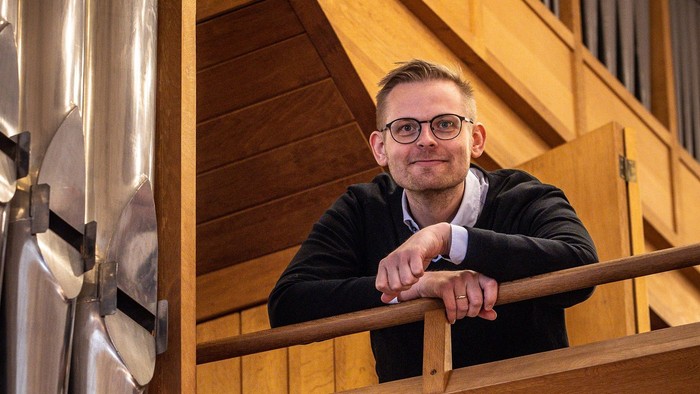 Mand med briller og svingere sidder på trappe.