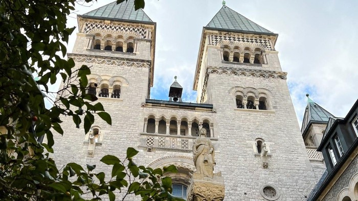 Zwei hohe Türme eines gotischen Gebäudes mit spitzen Dächern und zahlreichen Fenstern.