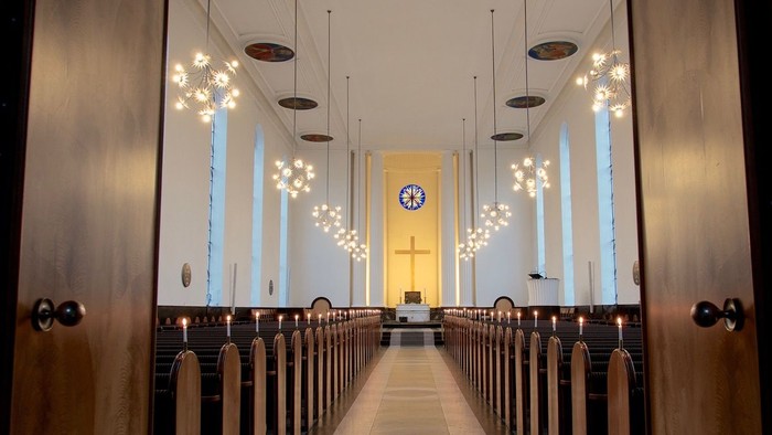 Indgang til kirke med lys og bænke.