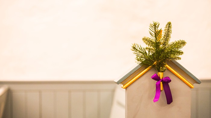 En lille juletree på en hvid skrin med guld og rosa bånd