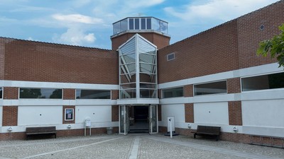 Et moderne bygning med en glasopstaltning og røde mursten.