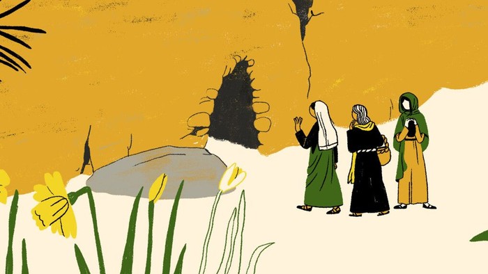 Tre kvinder i traditionelle kjoler går gennem et ørkenlandskab med gule blomster og en stenet bjergside.