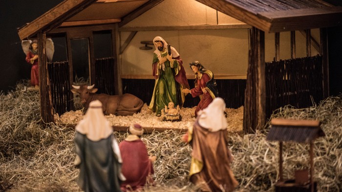 En julekredsen med Jesusbarnet, Maria og Josef i en stald med heste og okser.