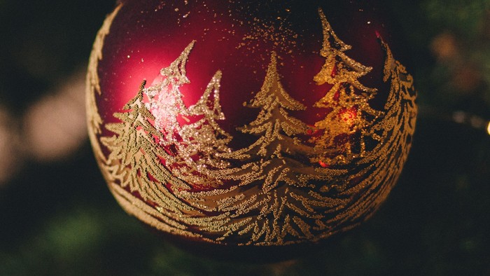 En juletree med røde glitrende pynt og lys.