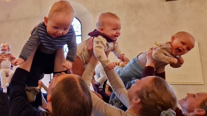 En gruppe børn spiller og leker i et rum med vinduesglas.