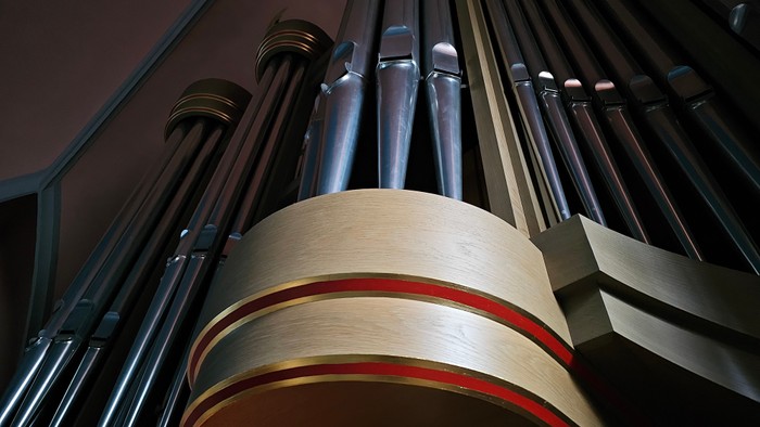 Nahaufnahme von Orgelpfeifen, die ihre metallene und hölzerne Konstruktion zeigt.
