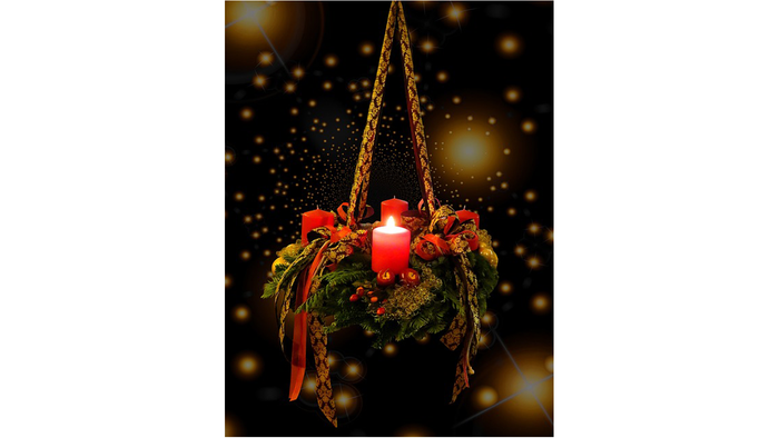 Ein Adventskranz mit vier Kerzen, geschmückt mit roten Bändern und Tannenzapfen, vor einem dunklen Hintergrund mit goldenen Lichtern.